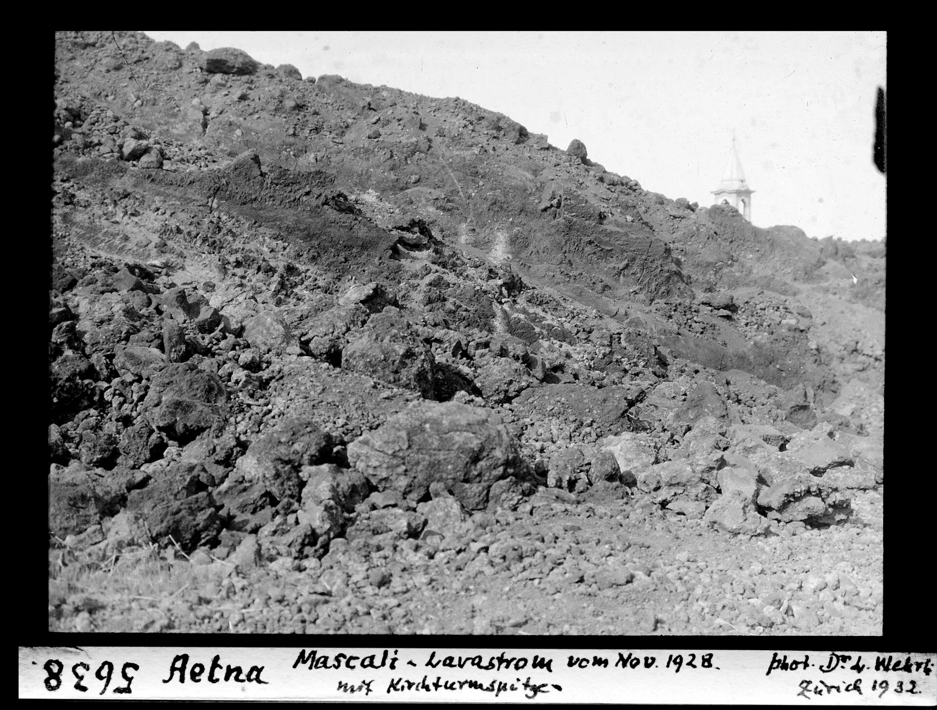 Historical photograph by Leo Wehrli: the cooled lava flow of 1928 in Mascali on Mount Etna, the tip of the church tower rising out of the lava behind it