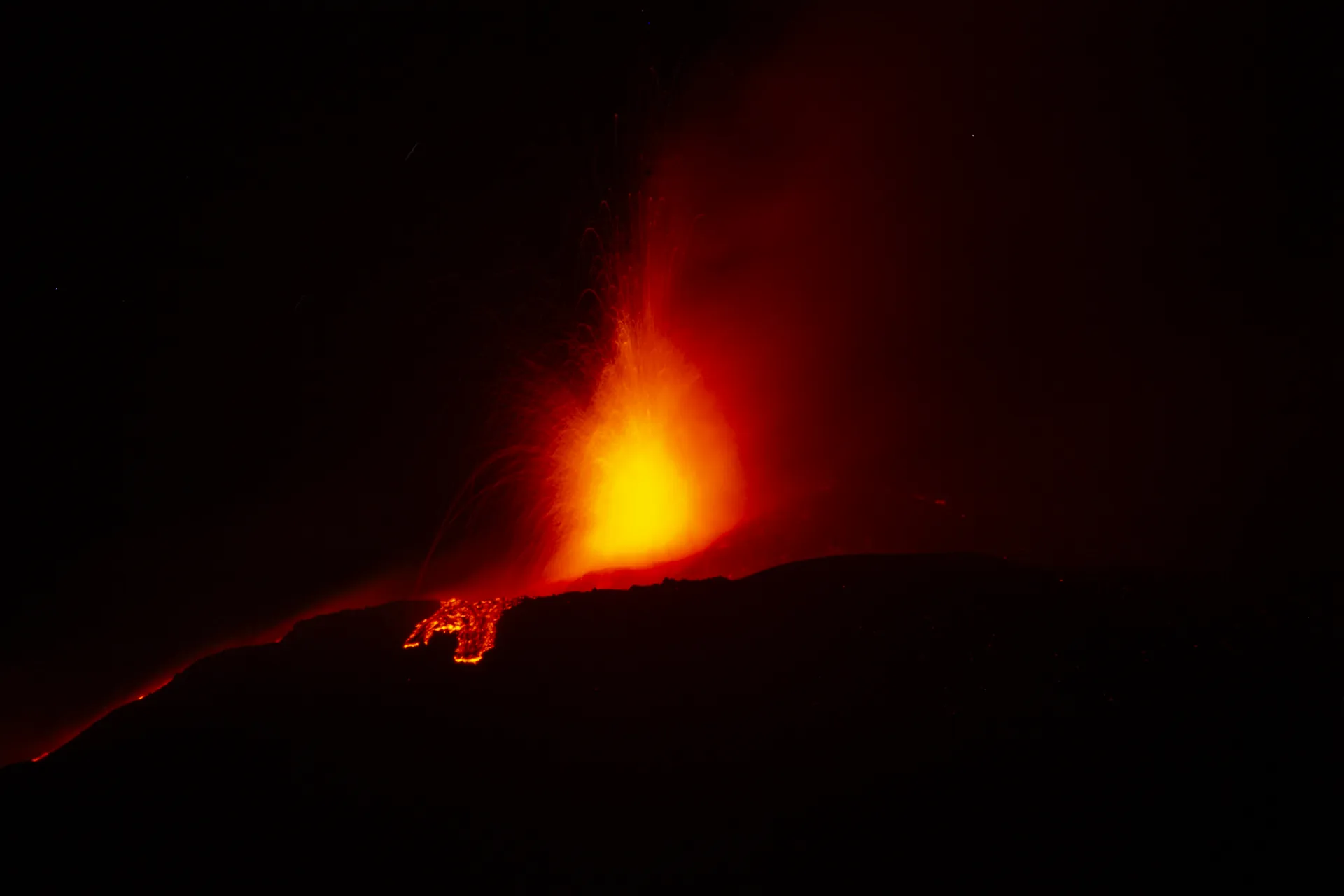 Lava fountain from the Voragine crater on Mount Etna in the night of August 15, 2024, seen from Adrano, with a glowing lava flow on the cone
