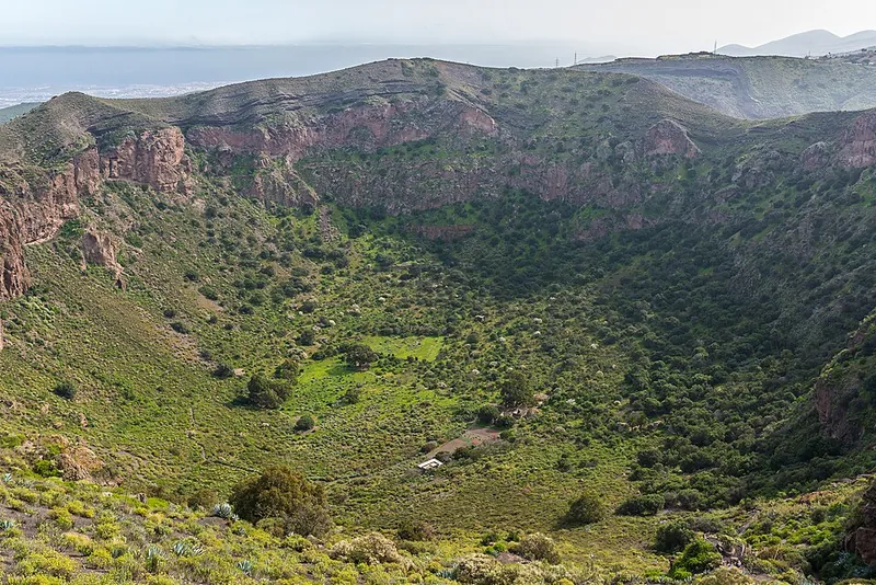 Blick vom Pico de Bandama in die Caldera de Bandama: steile Wände aus rotbraunem Lapilli, unten der grüne Kraterboden
