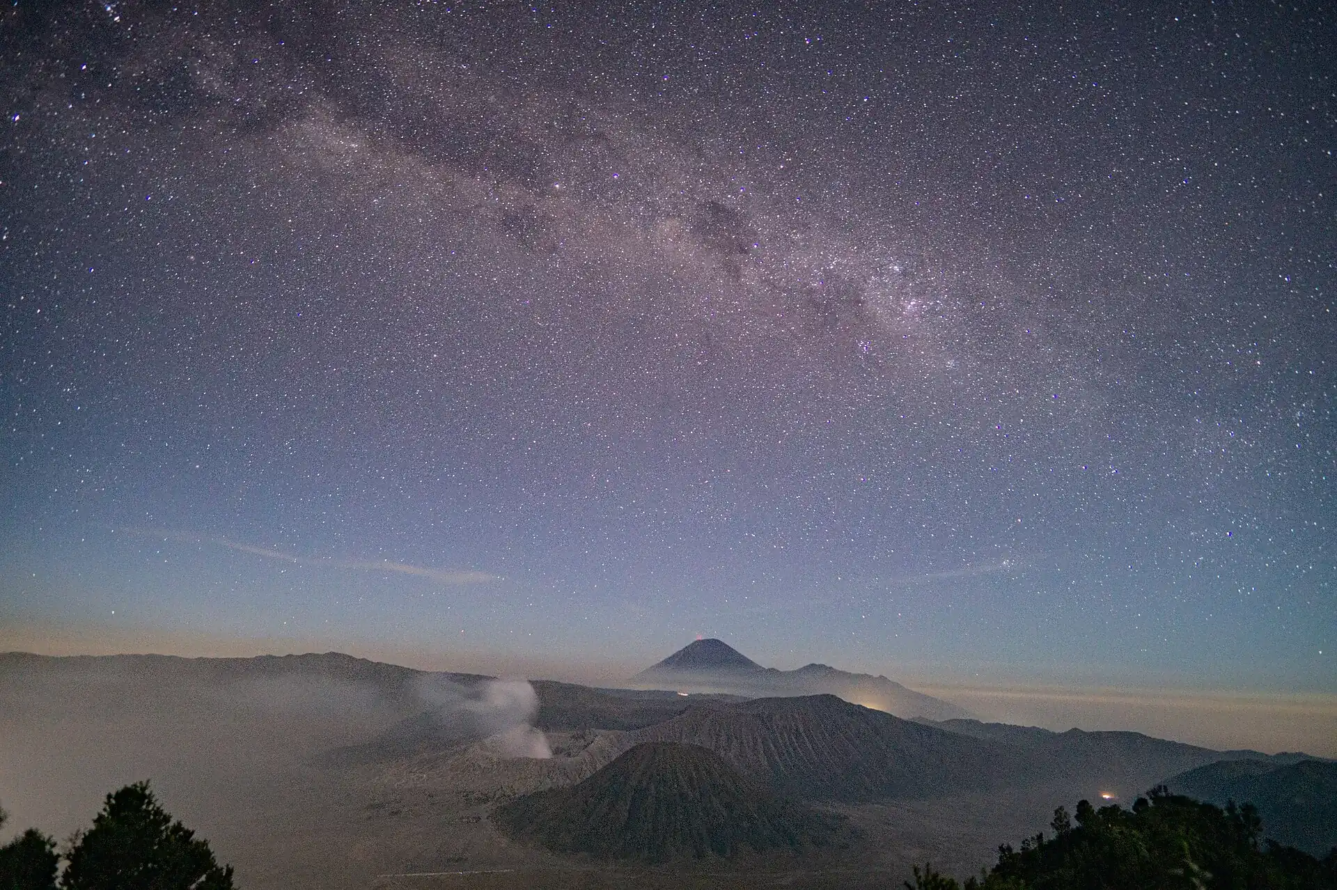 Starry sky with the Milky Way over the Tengger Caldera: the cones of Batok and Bromo in the haze, Semeru behind them