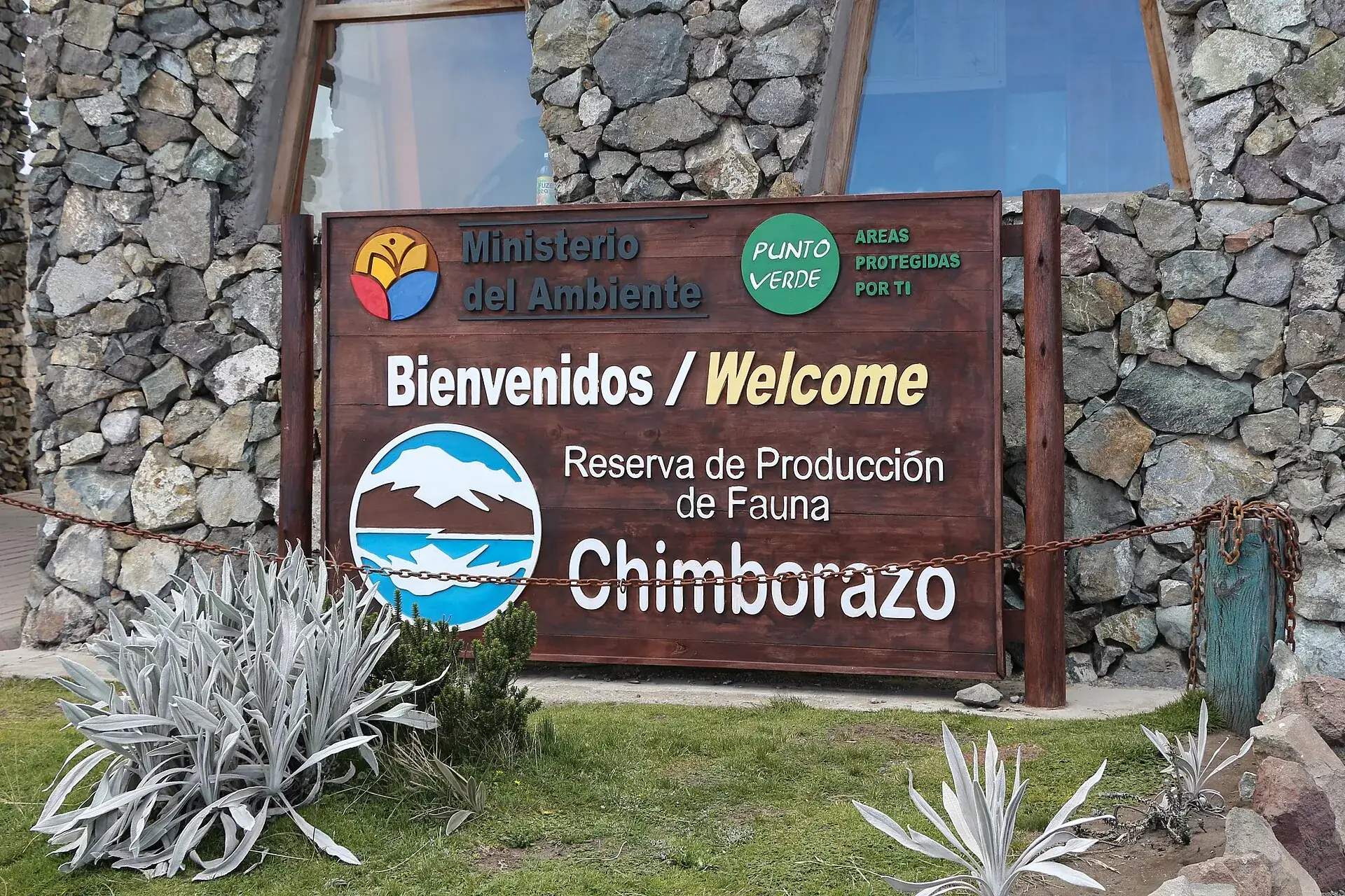 Das Willkommensschild der Reserva de Producción de Fauna Chimborazo des Umweltministeriums an einer Steinmauer