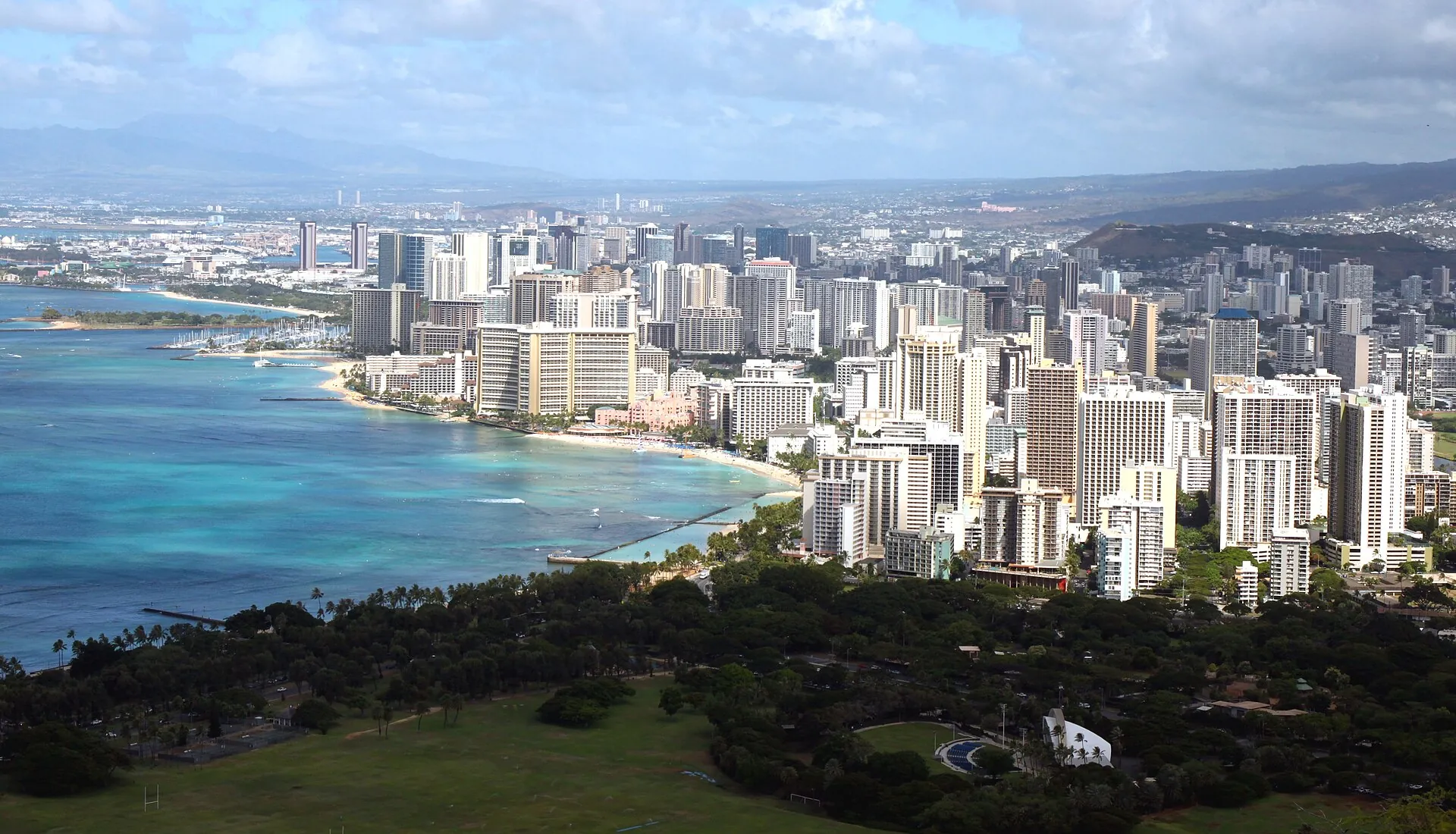 View from the summit of Diamond Head over the high-rises and beach of Waikīkī with turquoise water