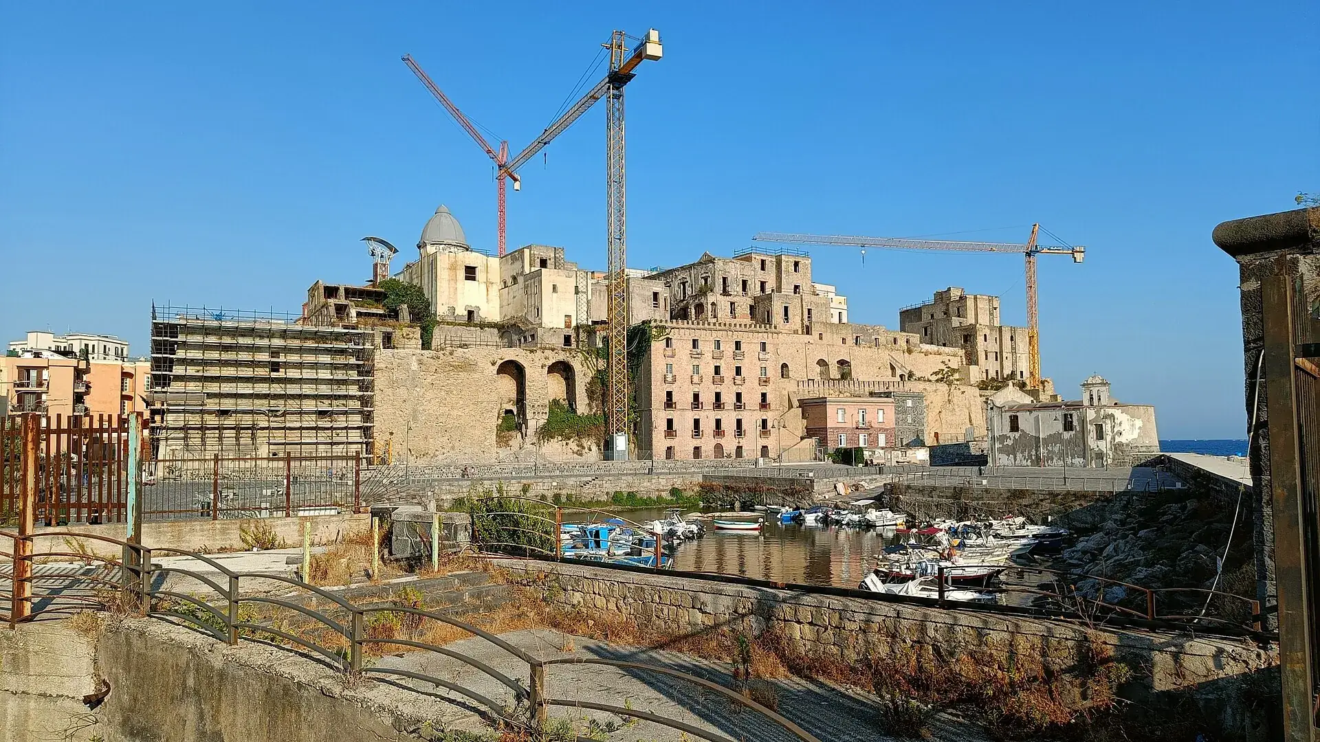 Der Rione Terra in Pozzuoli mit Baukränen über dem Hafen