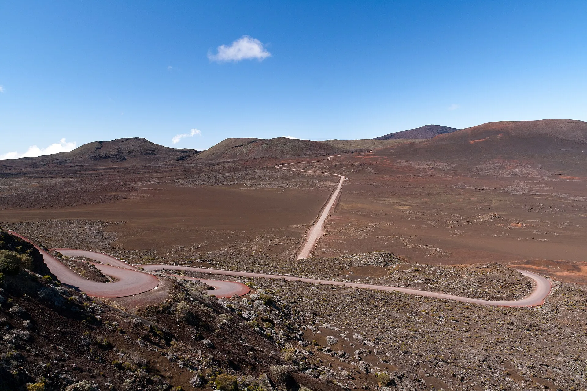The Route forestière du Volcan winding across the reddish-brown Plaine des Sables on Réunion