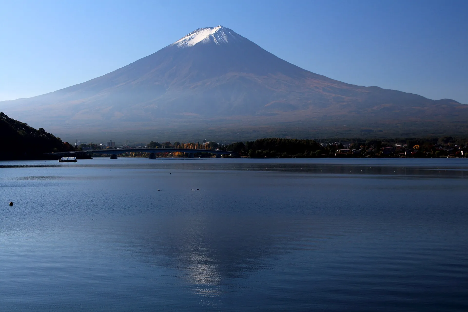 Mount Fuji with the first snow on its summit, seen across Lake Kawaguchi on a clear October morning