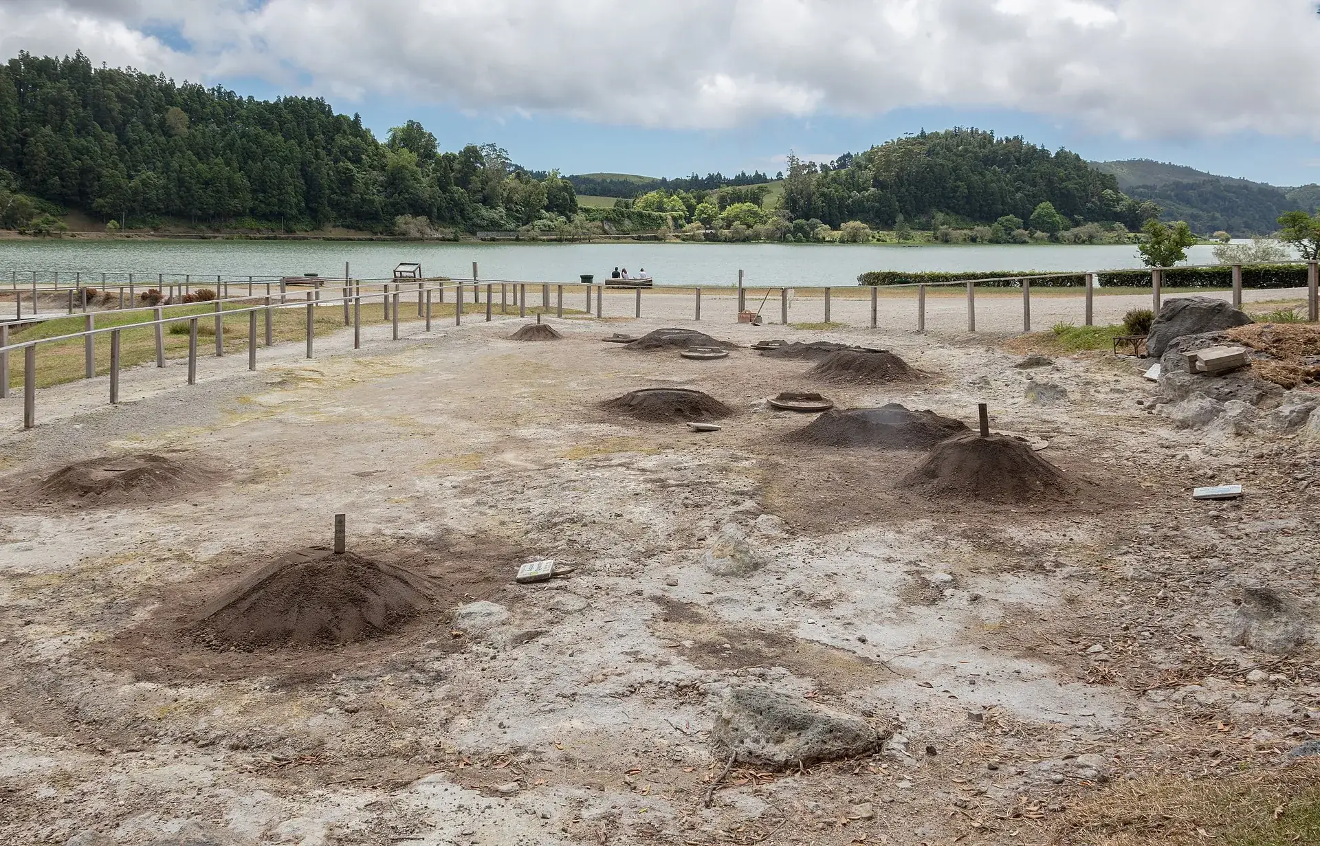 Erdhügel über den Cozido-Gruben in der Kochgruben-Zone an der Lagoa das Furnas, dahinter der See und die grünen Kraterwände