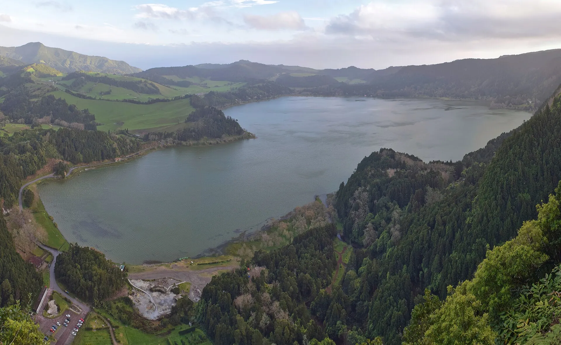 Die Lagoa das Furnas vom Miradouro do Pico do Ferro: der See im grünen Talkessel, am Südufer das helle Feld der Kochgruben