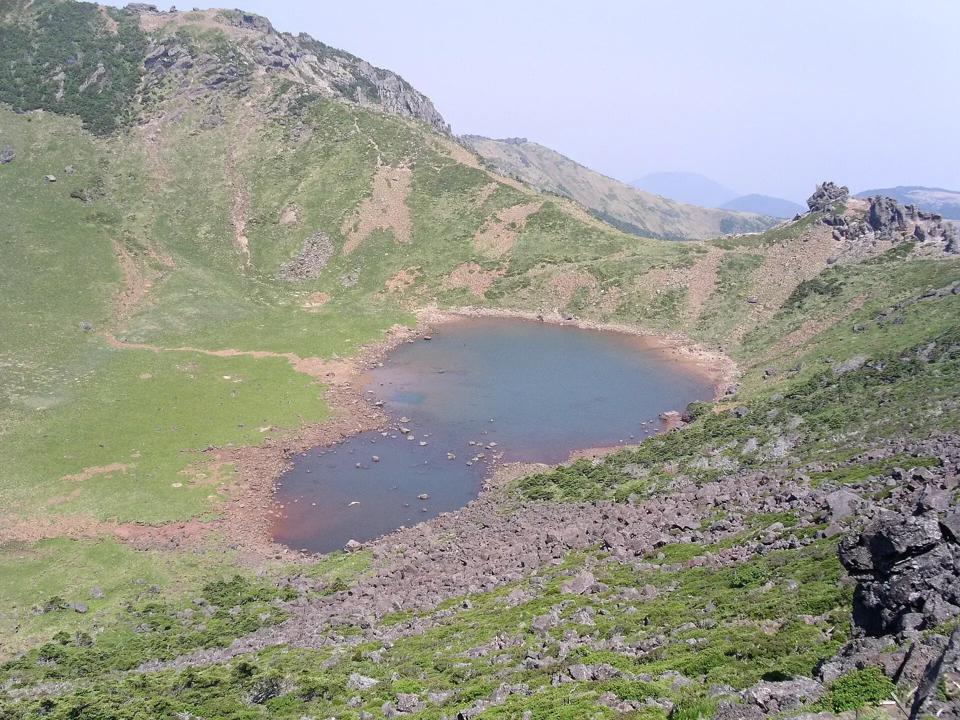 The crater lake Baengnokdam on the summit of Hallasan, ringed by grassy crater walls