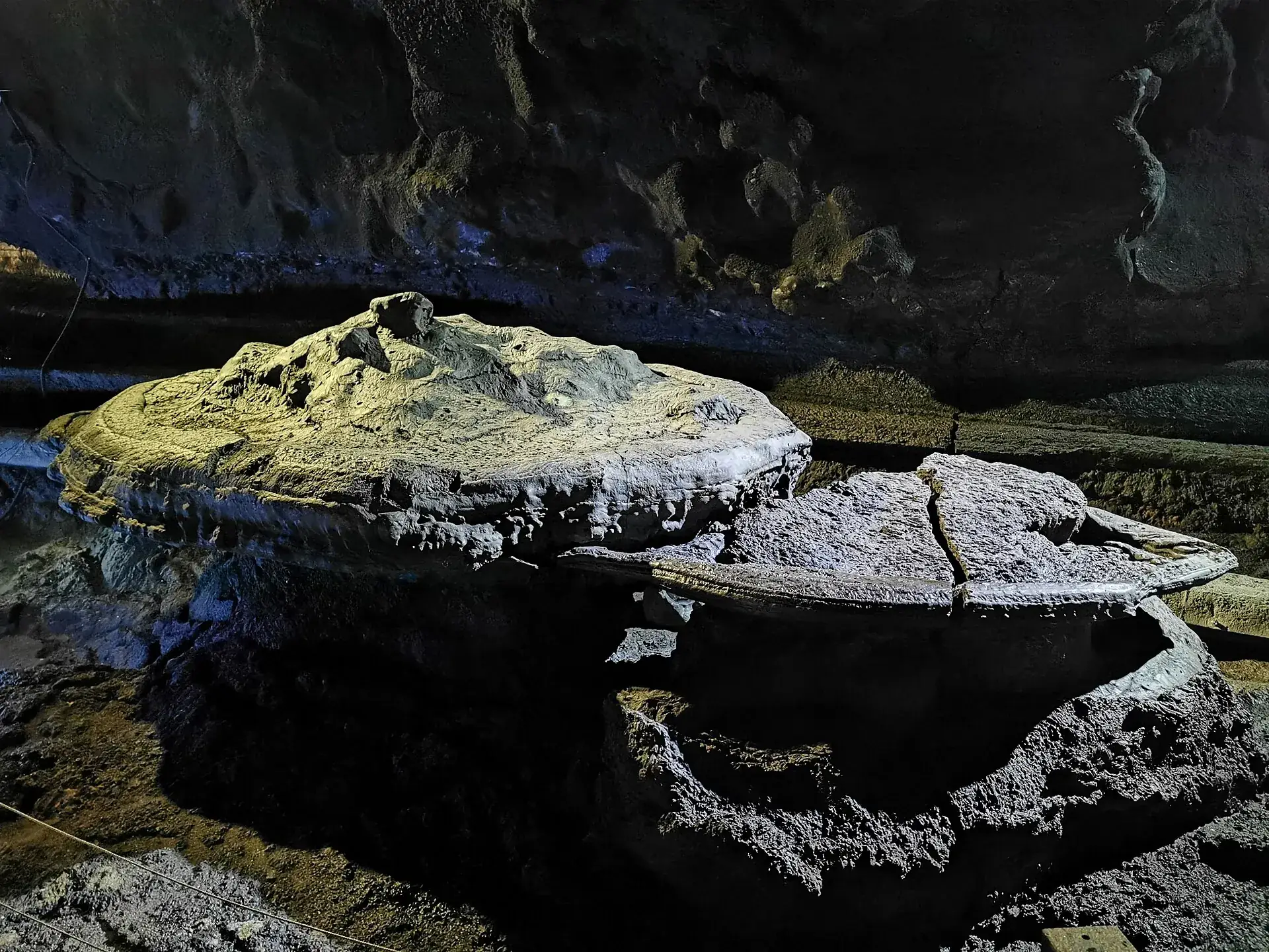 Solidified lava shapes and wall structures in the lit passage of the Manjanggul lava tube on Jeju