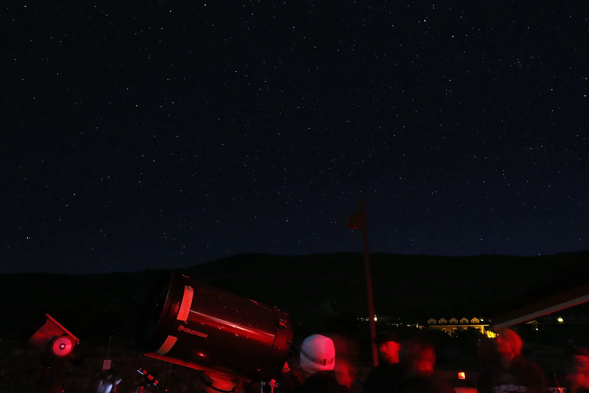 Stargazing at the Maunakea Visitor Information Station: visitors in red light around a telescope under the night sky