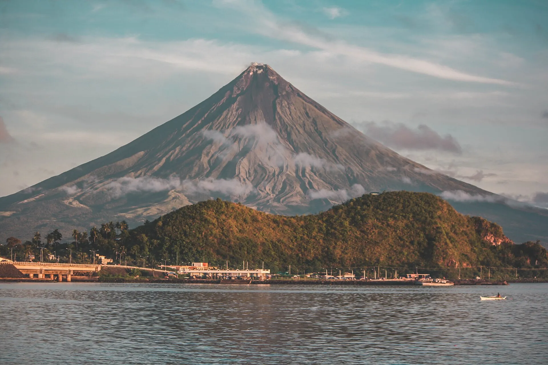 Der Mayon hinter einem langgestreckten, bewaldeten Hügelrücken, der wie ein liegender Löwe aussieht