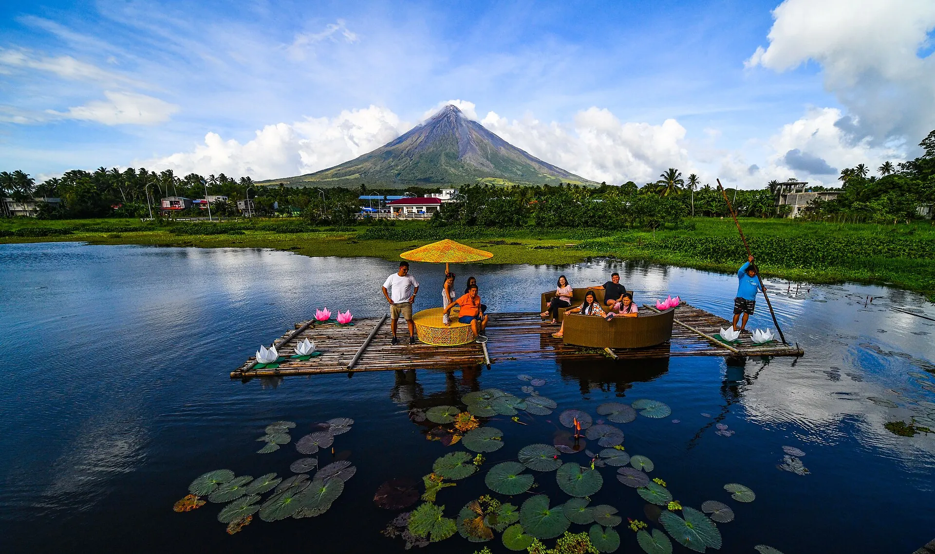 Der Mayon spiegelt sich im ruhigen Wasser des Sumlang Lake bei Camalig, am Ufer liegen Bambusflöße