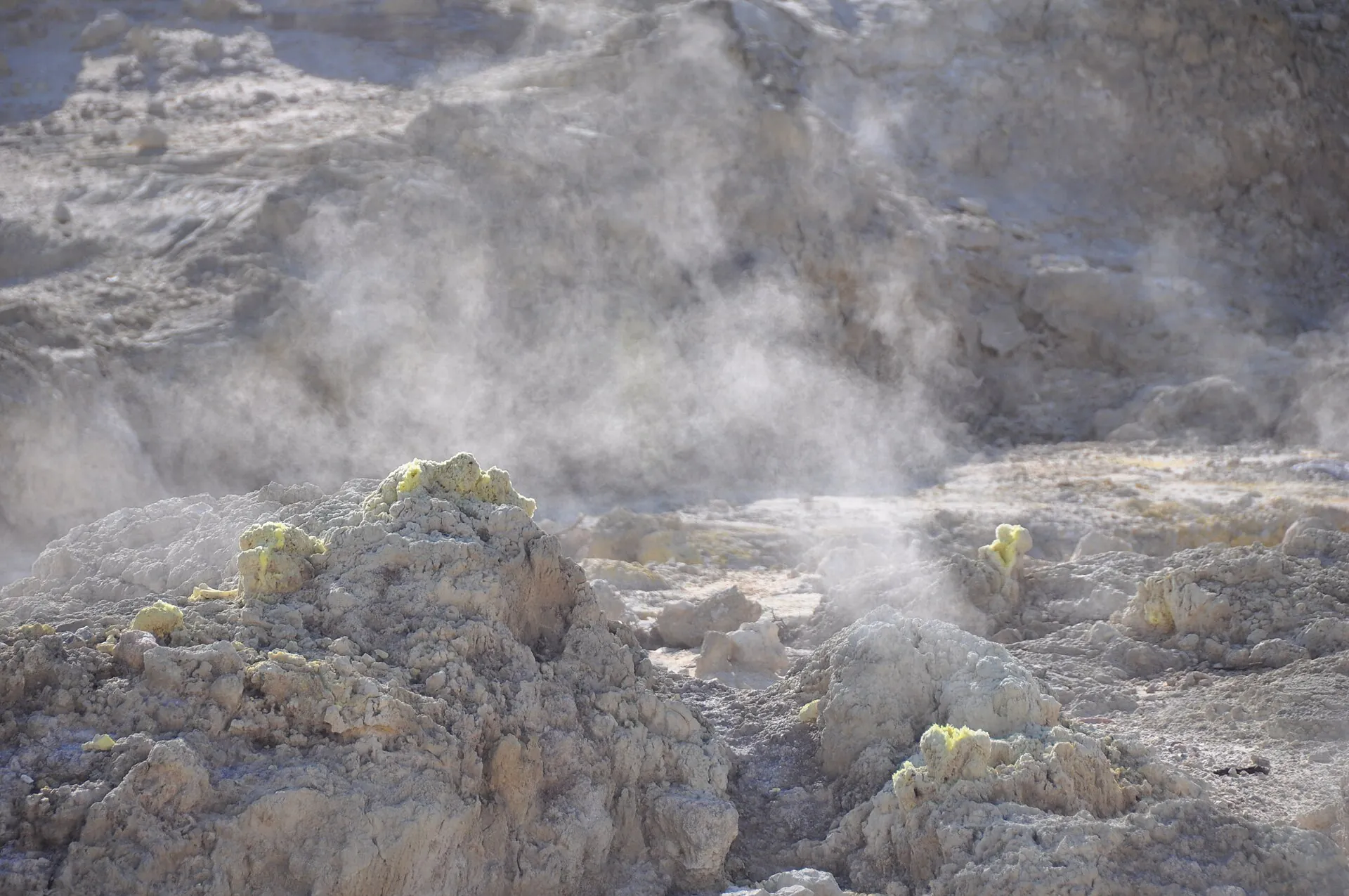 Dampf steigt aus Fumarolen auf dem Kraterboden des Stefanos auf Nisyros, um die Öffnungen gelbe Schwefelkrusten