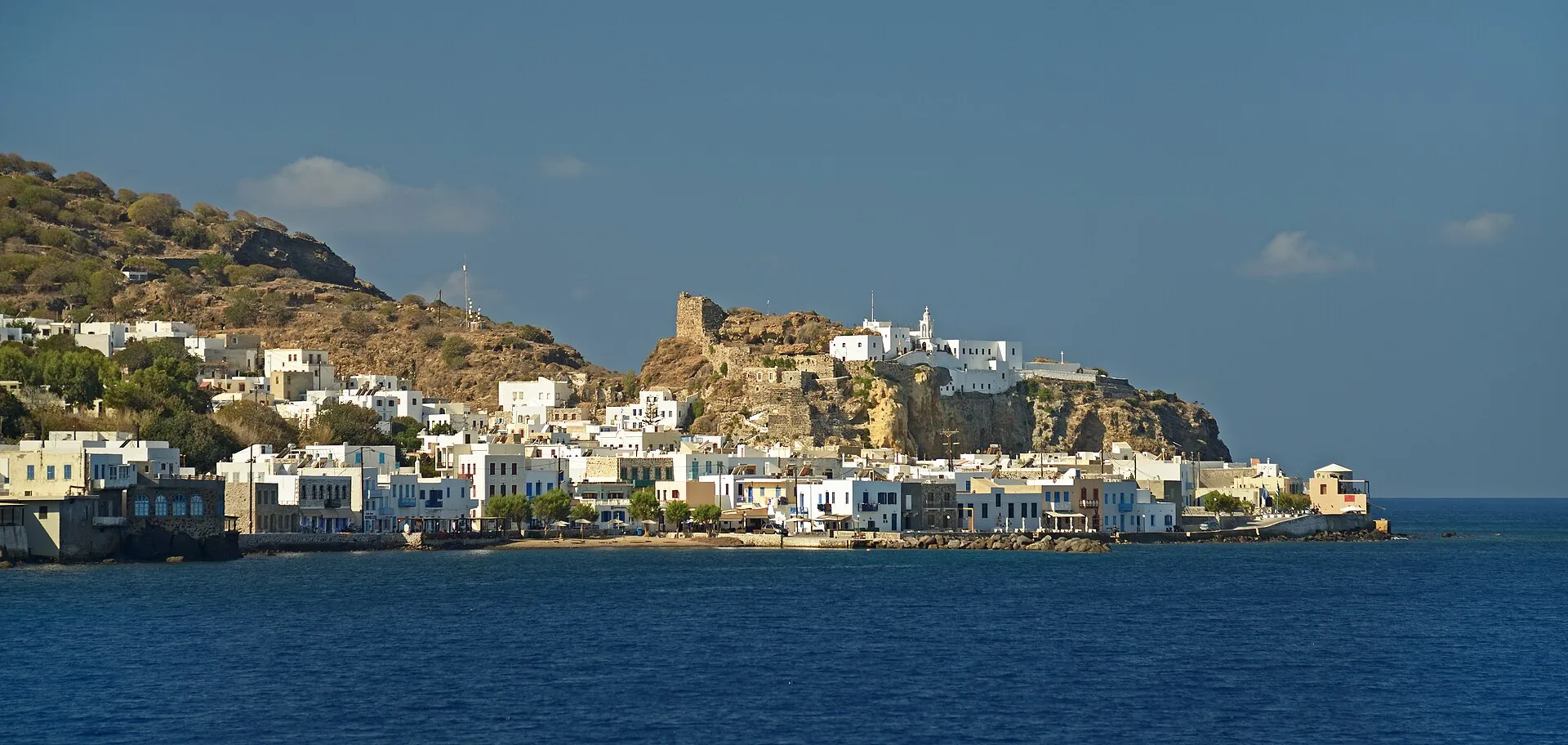 Mandraki auf Nisyros vom Meer aus: weiße Häuser unter dem Klosterfelsen der Panagia Spiliani