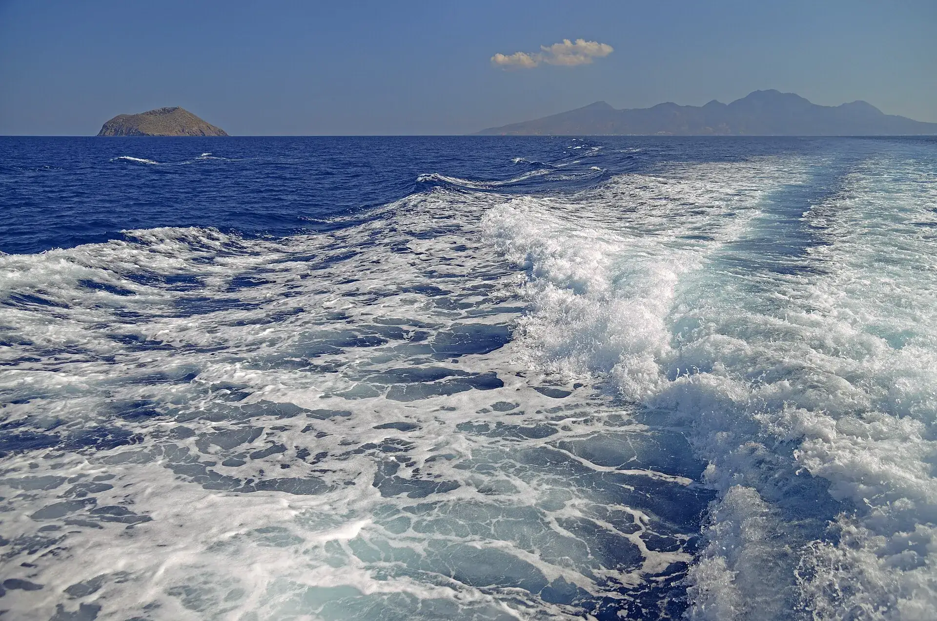 Kielwasser eines Ausflugsboots in der Ägäis, am Horizont das Inselchen Strongyli und die Berge von Nisyros