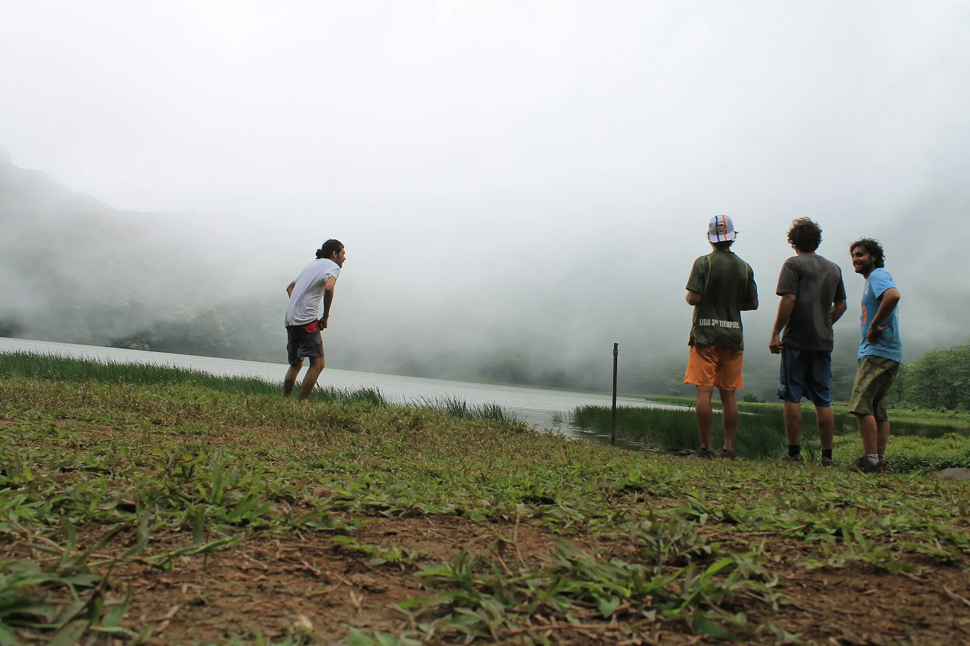 Vier Wanderer stehen im Nebel am Ufer des Kratersees auf dem Maderas, Ometepe