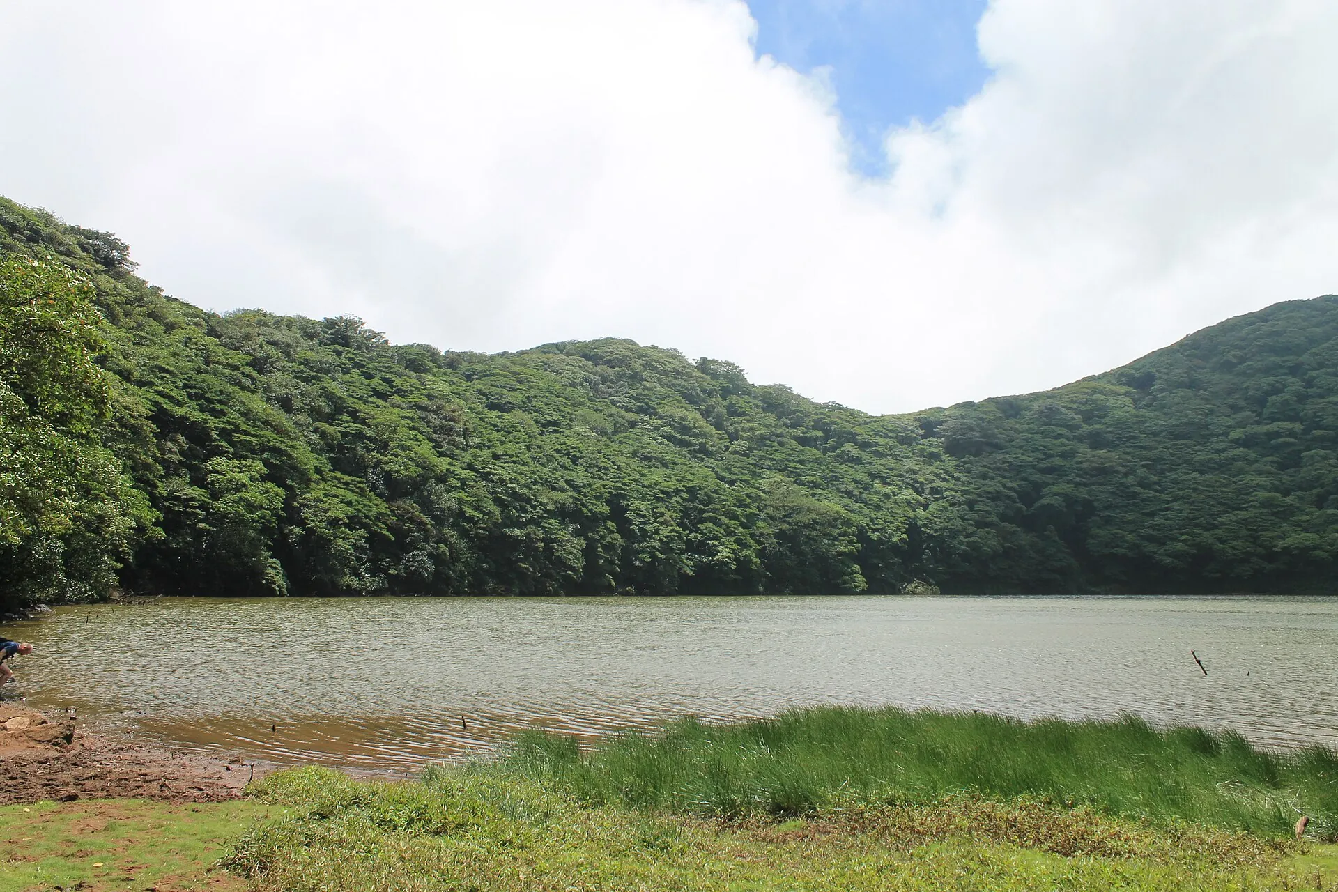 Der Kratersee des Maderas auf Ometepe: dunkles Wasser, umgeben von dichtem grünen Nebelwald unter Wolken