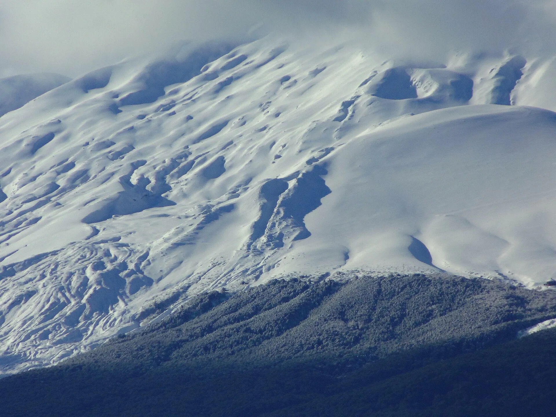 The glacier on Osorno up close: wind-sculpted snow over ice and dark channels