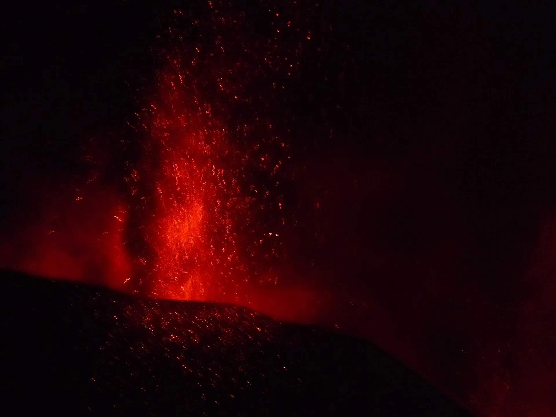 Night-time lava fountain of the 2021 Cumbre Vieja eruption: glowing red scoria shoots out of the cone into the darkness