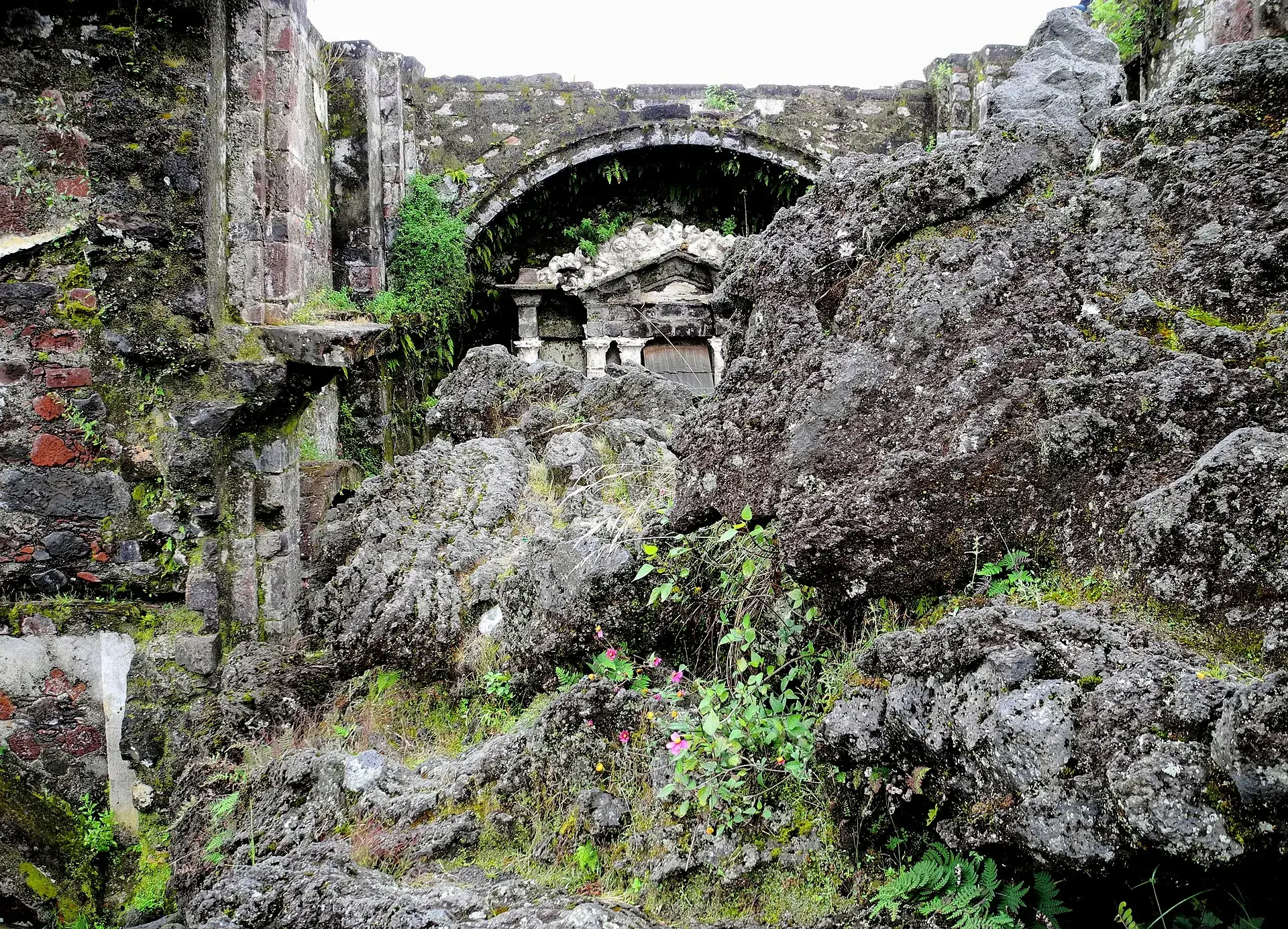 Der Altarraum der Kirchenruine von San Juan Parangaricutiro: Lavablöcke füllen das Kirchenschiff bis zum steinernen Altar unter dem Bogen
