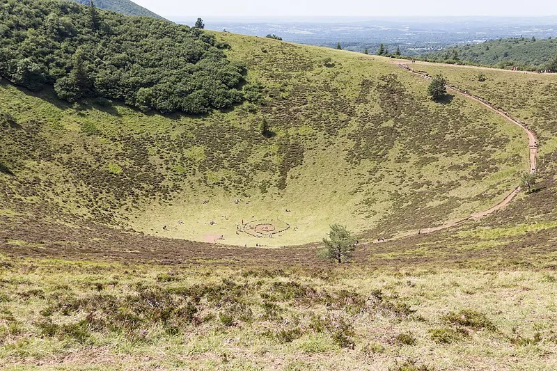 Der grasbewachsene Krater des Puy de Pariou in der Chaîne des Puys, ein Weg führt am Kraterrand entlang