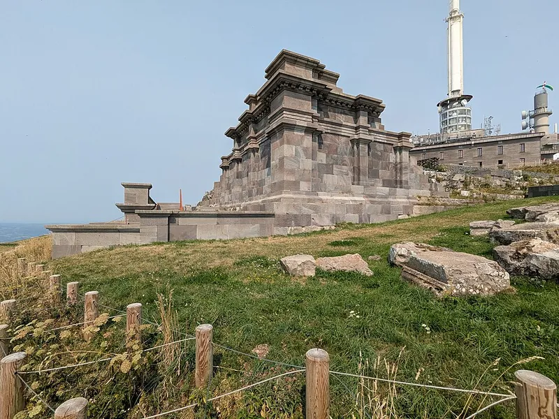 Die rekonstruierten Mauern des Merkurtempels auf dem Gipfel des Puy de Dôme, dahinter der Sendemast
