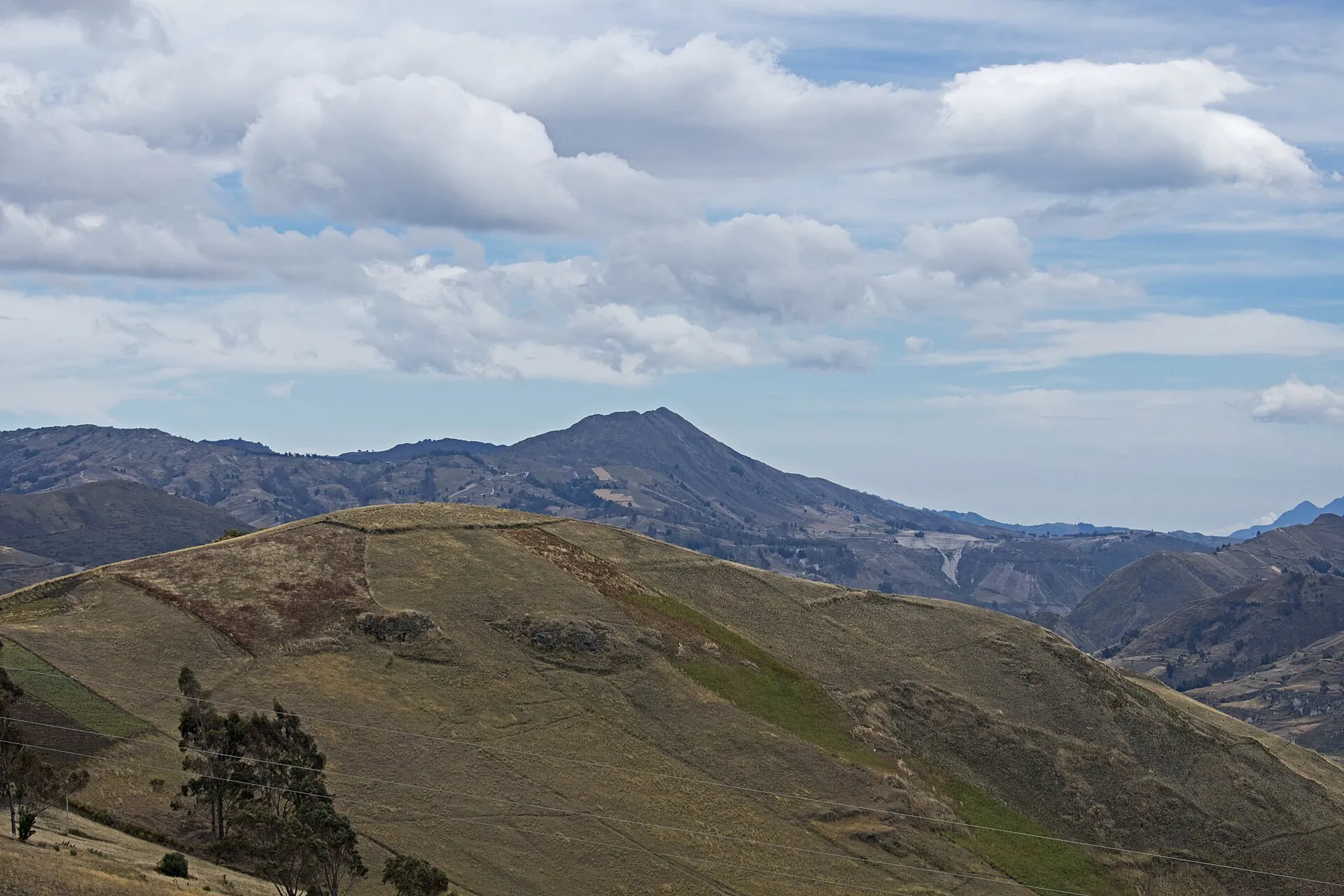 Highland landscape near Tigua: rolling hills with fields and paths, the country the Quilotoa Loop crosses