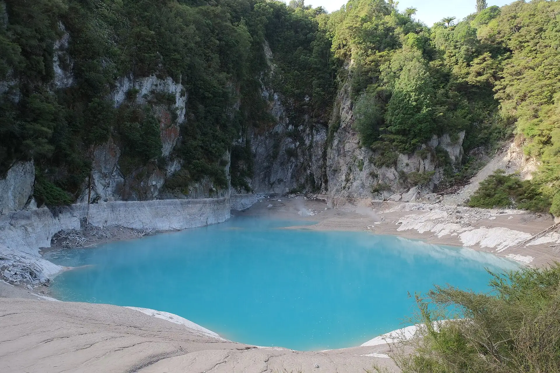 Inferno Crater in the Waimangu Volcanic Valley near Rotorua: a turquoise crater lake below pale, vegetated crater walls