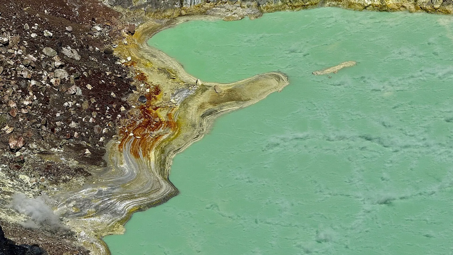Close-up of the crater lake at Santa Ana Volcano: milky green water with yellow and rust-red edges of sulfur and iron