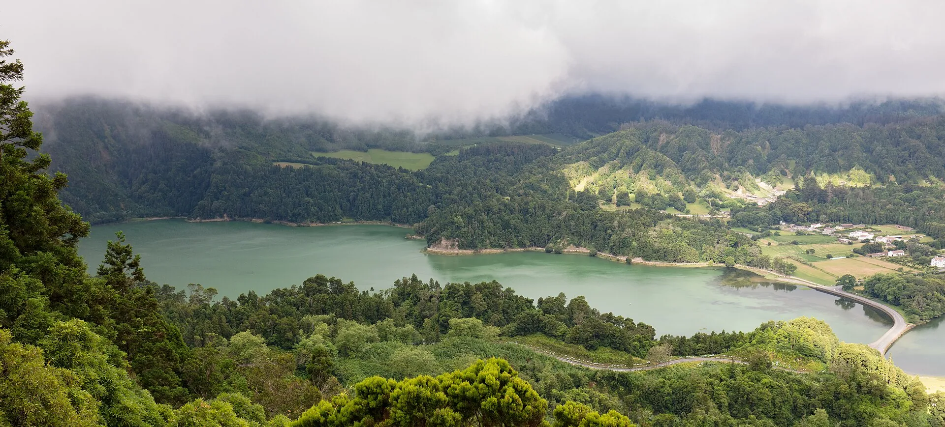 Lagoa Verde in Sete Cidades under low cloud, the crater walls disappearing into fog