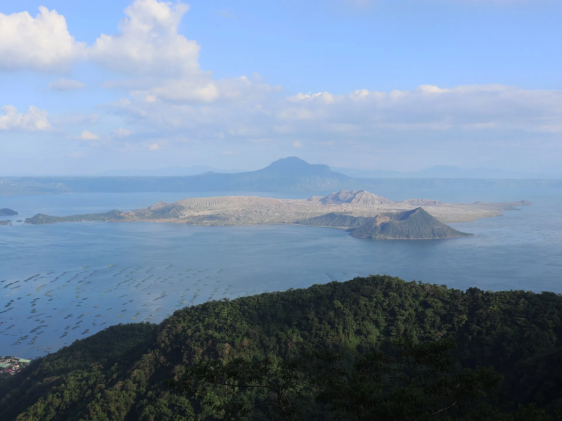 Die Vulkaninsel im Taalsee vom Calderarand bei Tagaytay aus, links ein kleiner Nebenkegel, dahinter die Berge von Batangas