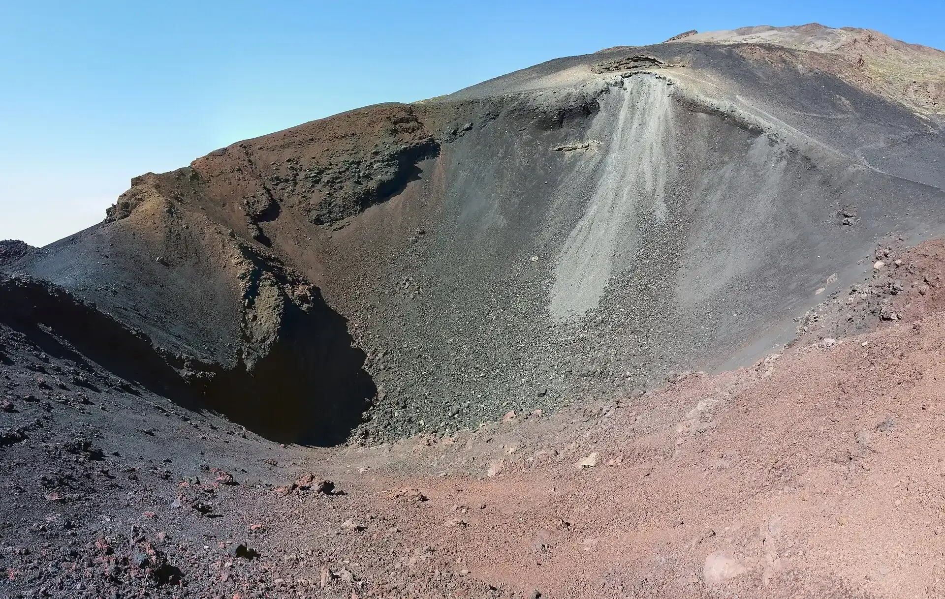 Der Krater der Narices del Teide mit schwarzer und roter Schlacke, dahinter der Hang des Pico Viejo