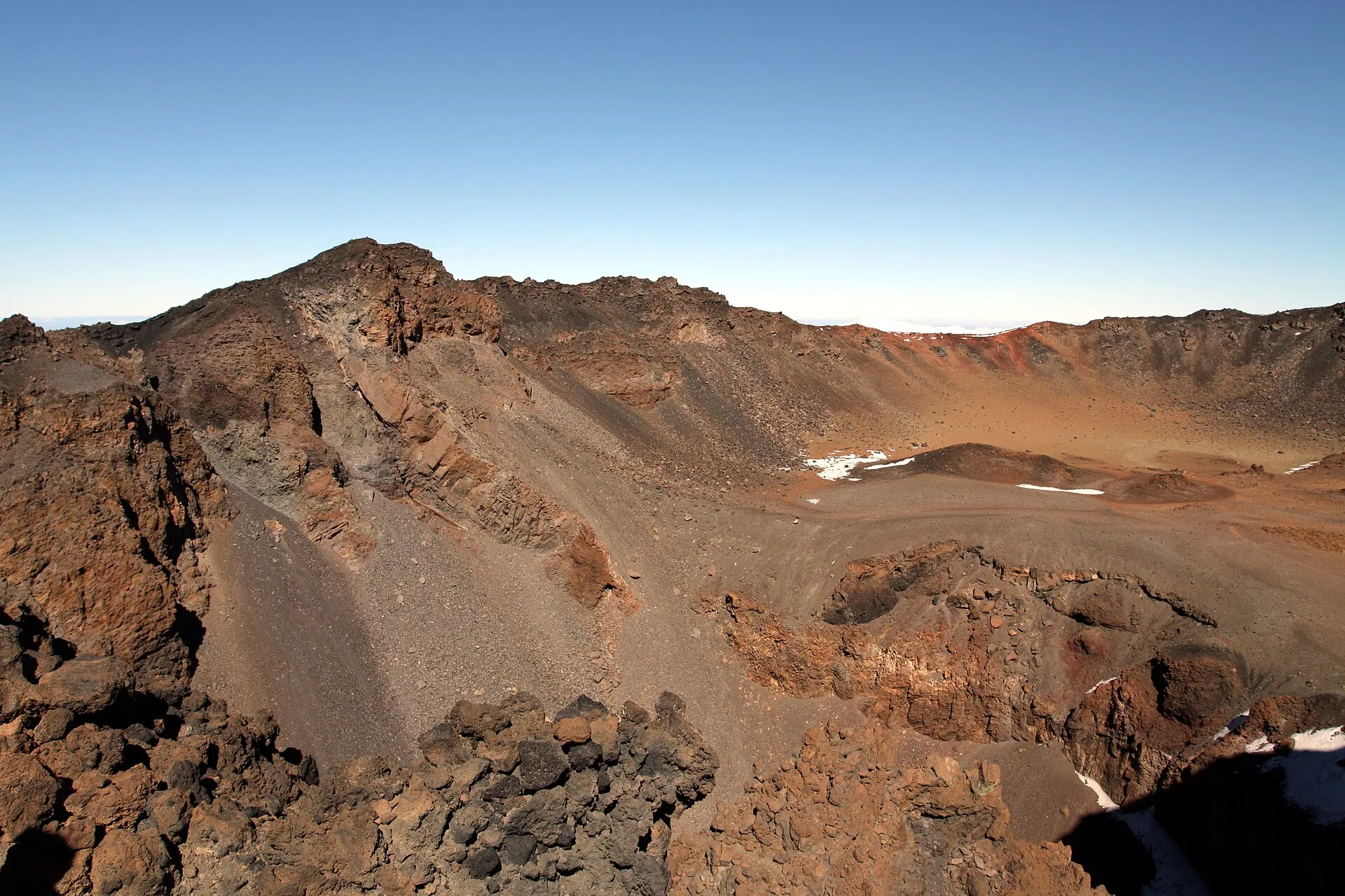 Der Krater des Pico Viejo auf Teneriffa mit Schneeresten am Boden, im Hintergrund der Kraterrand