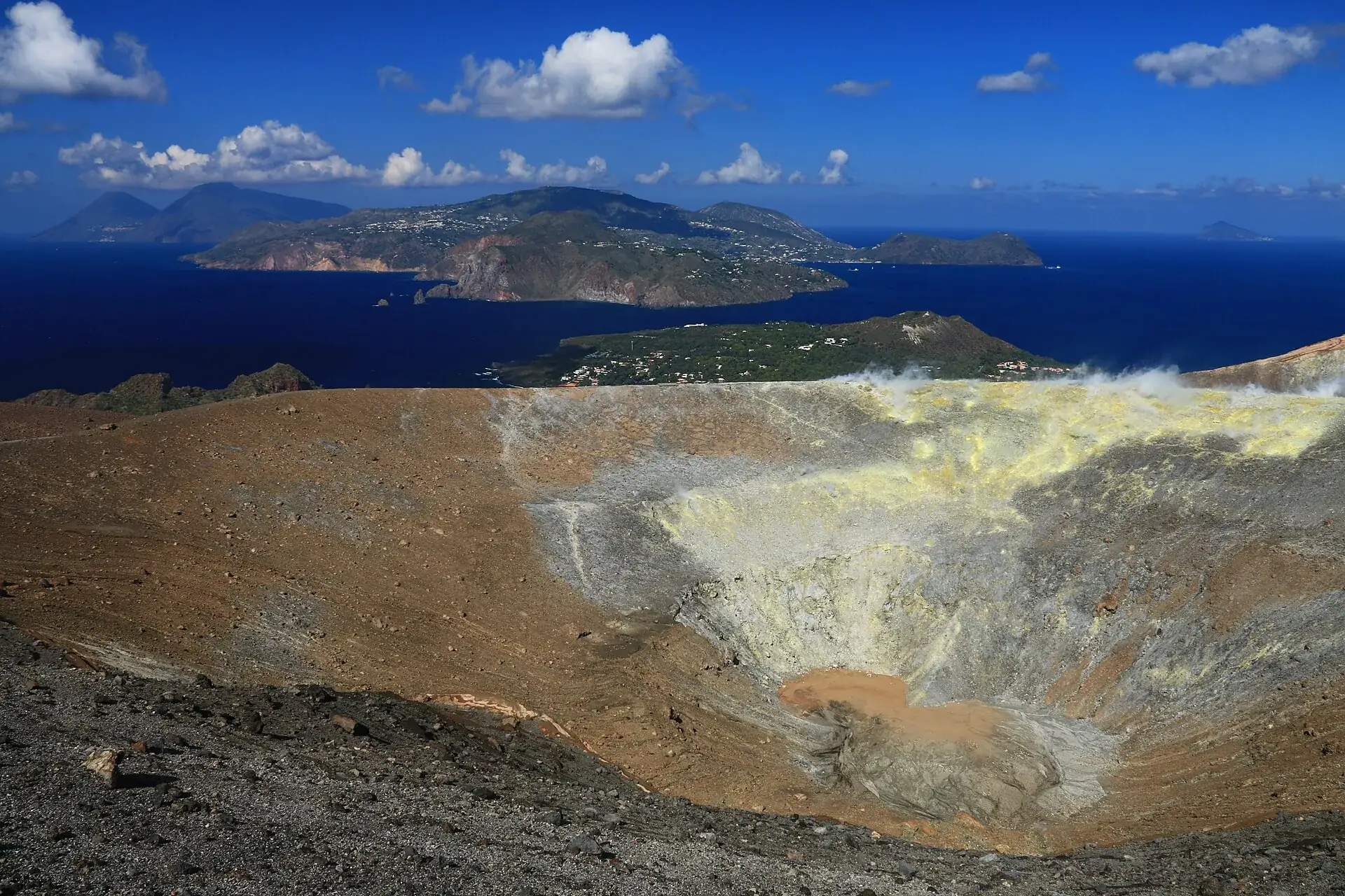 Der Gran Cratere auf Vulcano von oben, dahinter Lipari und die anderen Liparischen Inseln im Meer