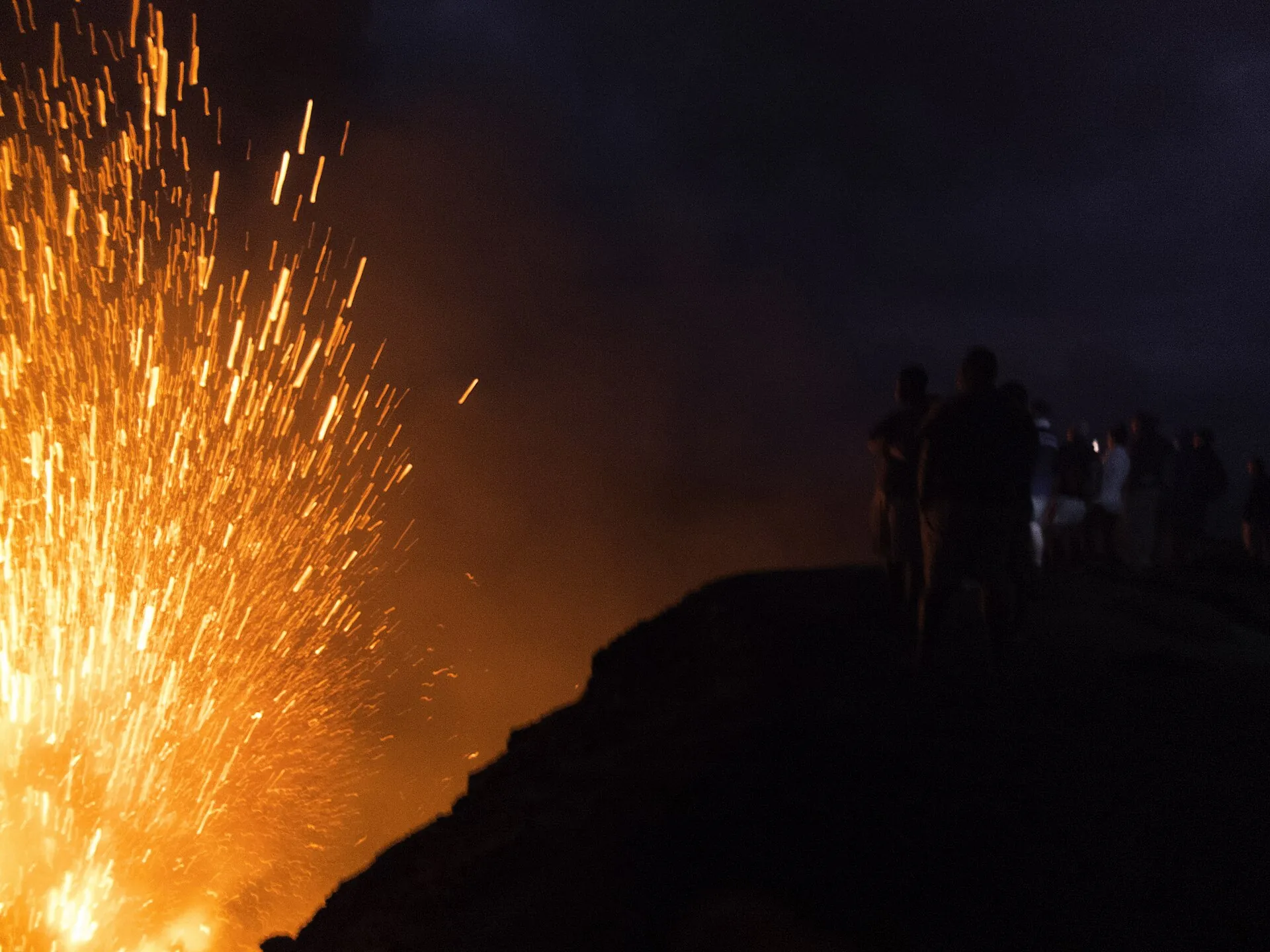 Besucher stehen am ungesicherten Kraterrand des Mount Yasur, unter ihnen der rauchende Schlot